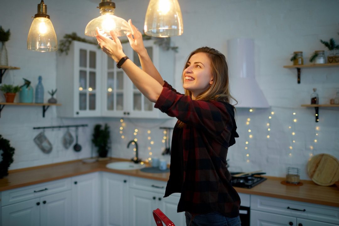 Woman changing light fixtures