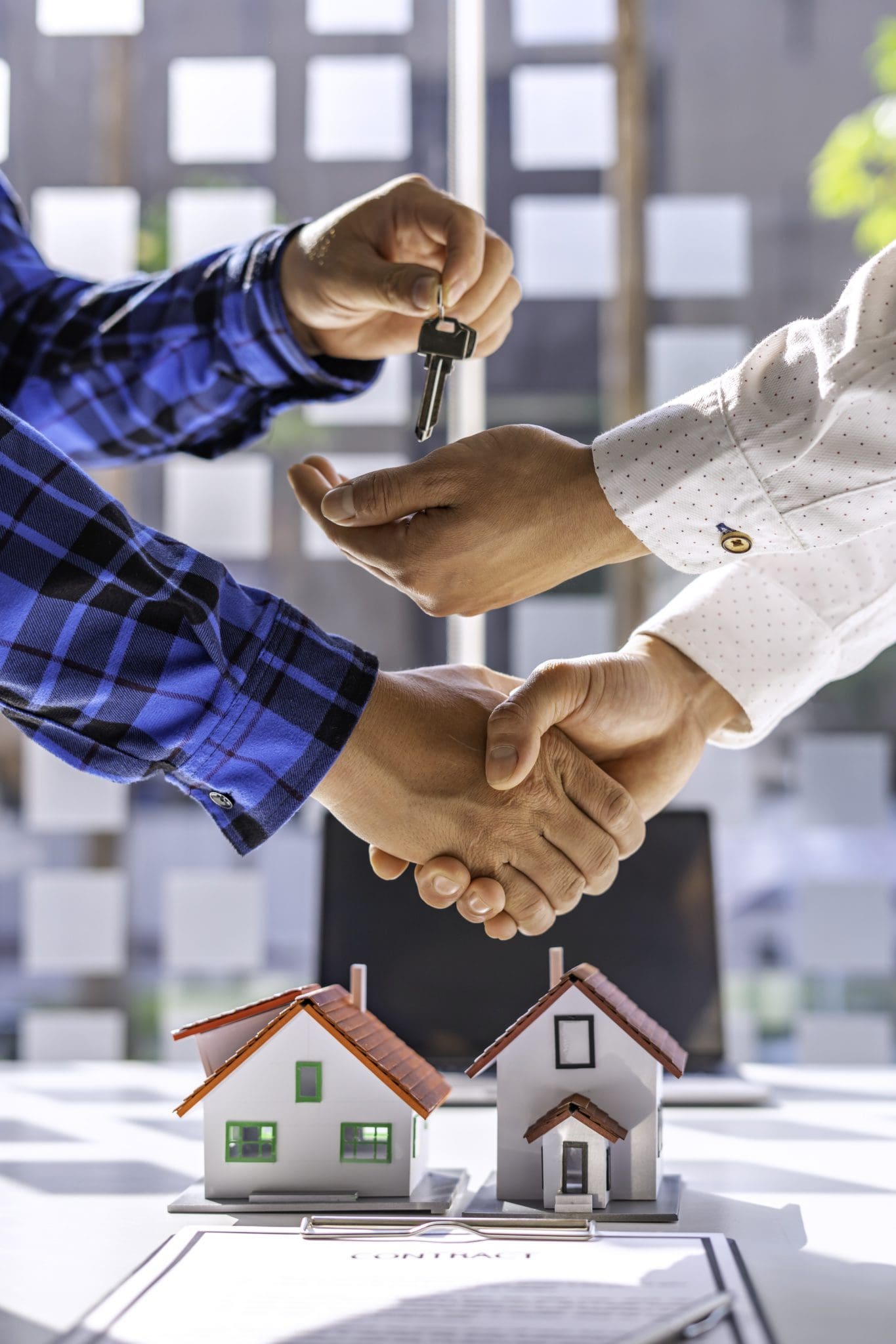 Real estate agents and clients shake hands and deliver the keys. After signing the contract to purchase ownership, the concept mortgage loan is approved.