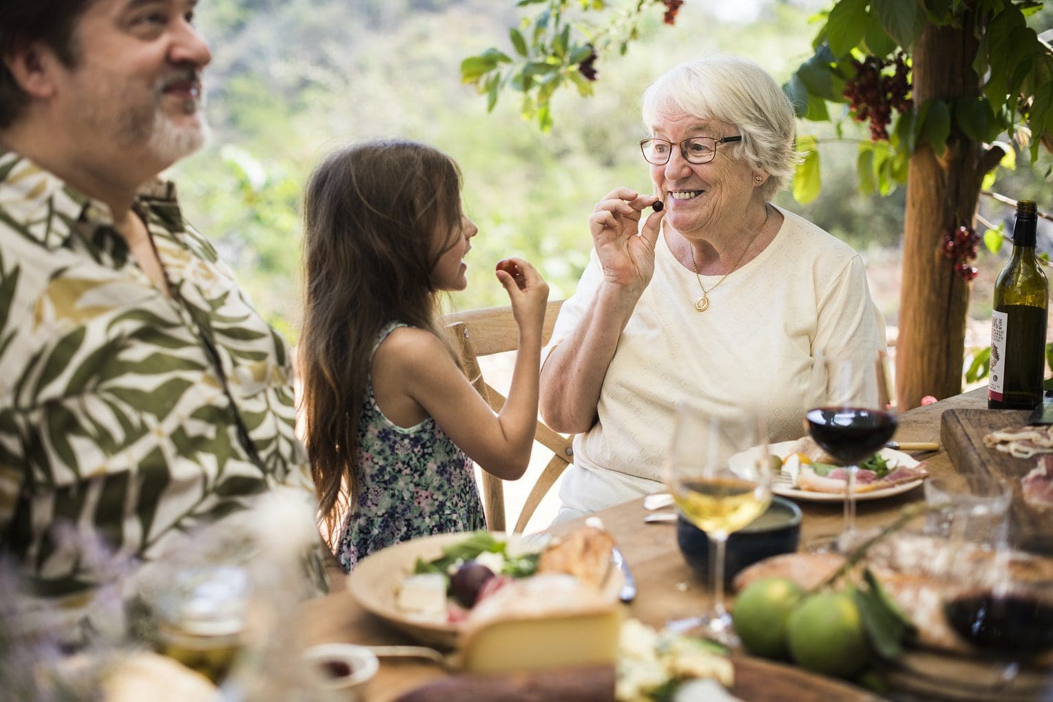 grandmother and grand daughter laughing and eating in outdoor luxury kitchen