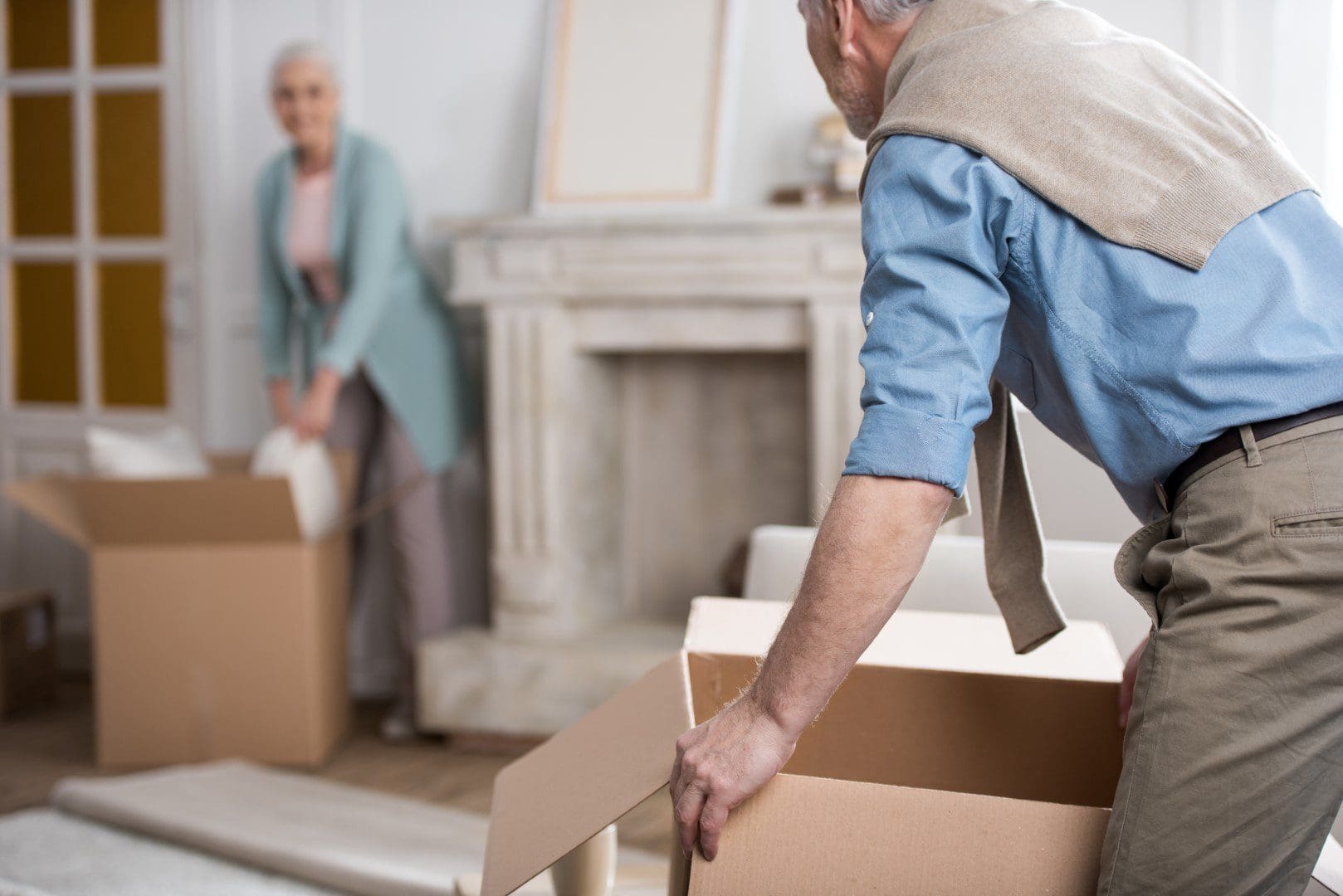 Senior couple packing moving boxes
